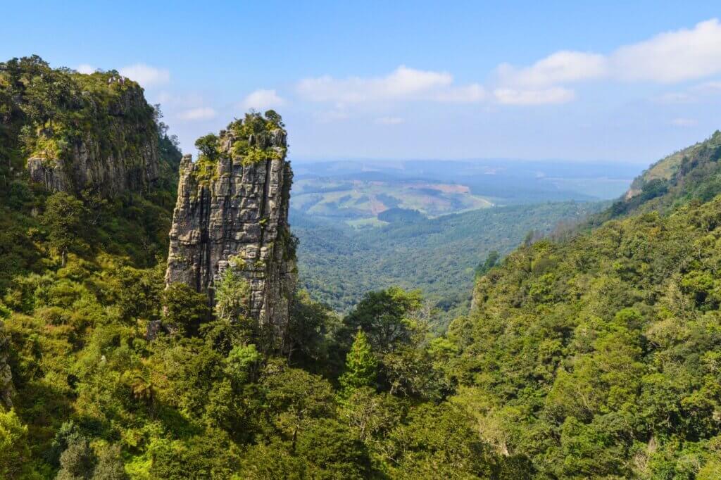 Blicke auf den steilen Pinnacle Rock inmitten einer grünen Schlucht