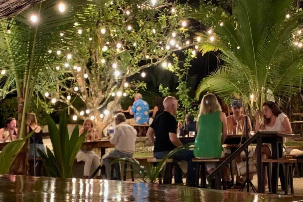 Genieße Cocktails unter Lichterketten im tropischen Garten