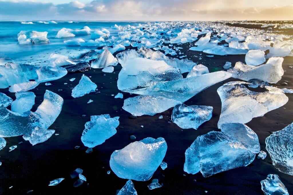 Erlebe schwarzen Sandstrand übersät mit Eisdiamanten