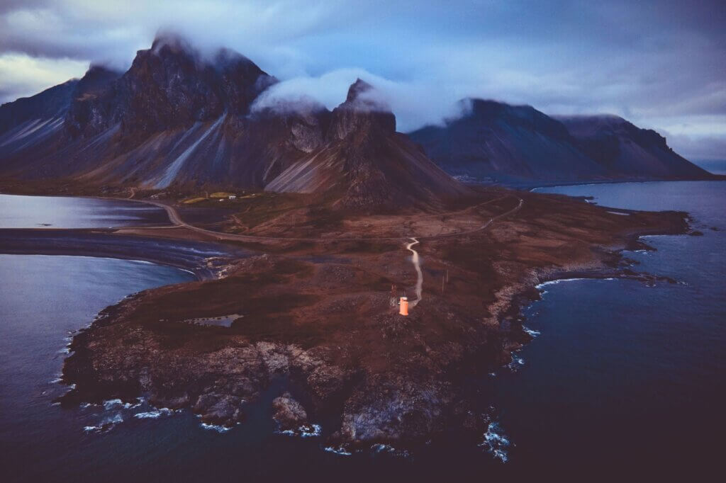 Fotografiere den orangefarbenen Hvalnes Leuchtturm an der Küste