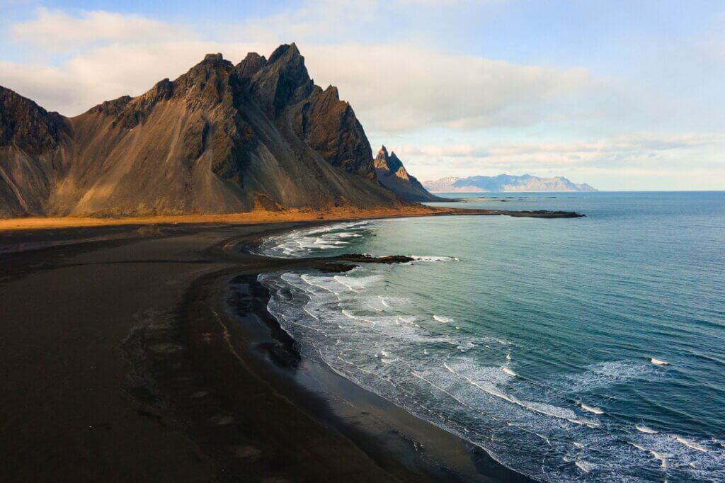 Erlebe die schwarze Küste und die dramatischen Berge dahinter