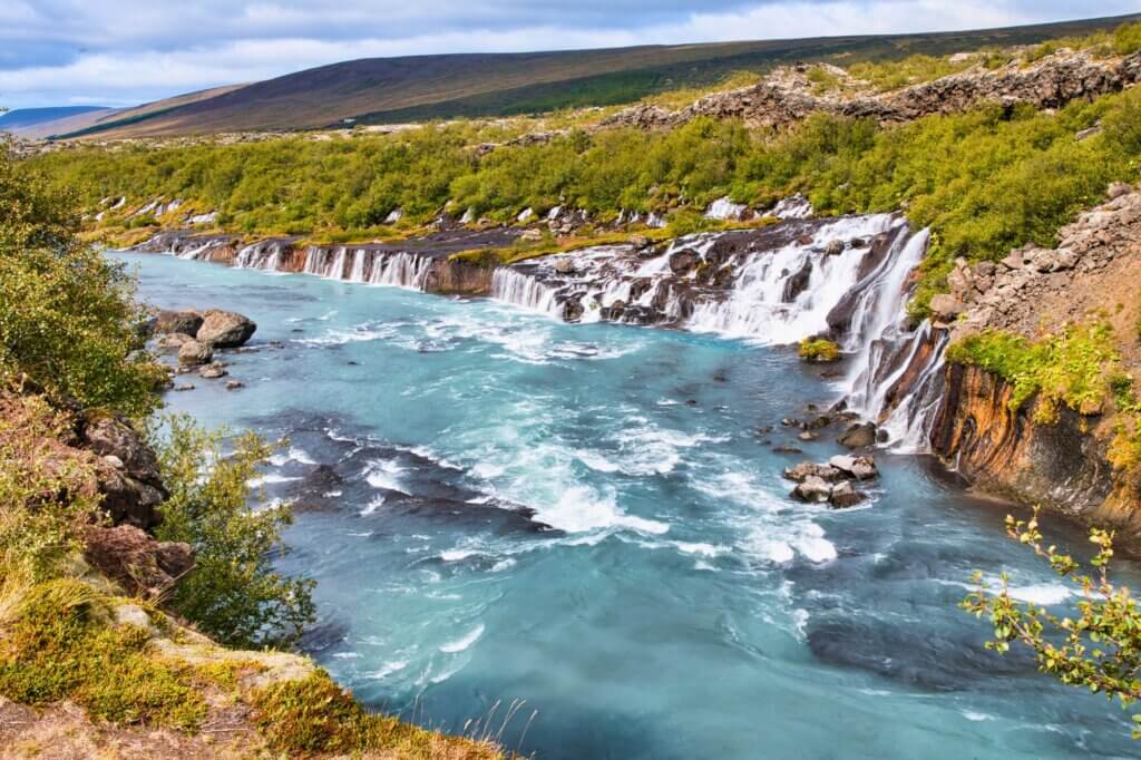Wandere zum Barnafoss und den benachbarten Hraunfossar-Fällen